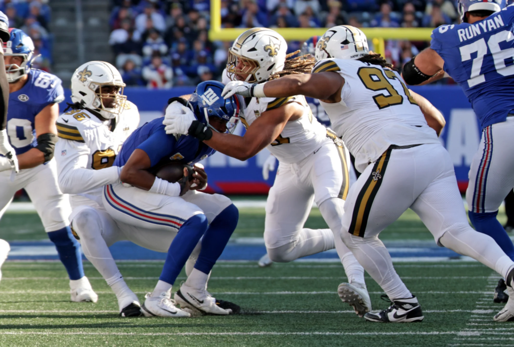 Os edges Carl Granderson (96) e Chase Young (99) trabalhando em conjunto para levar o querterbacj Jameis Winston para o chão (Layne Murdoch Jr. / New Orleans Saints)