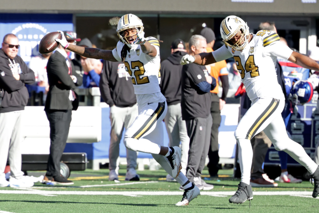 O cornerback Martin Emerson Jr. comemorando sua interceptação em Jameis Winston sendo perseguido por Cam Jordan (94) (Layne Murdoch Jr. / New Orleans Saints)